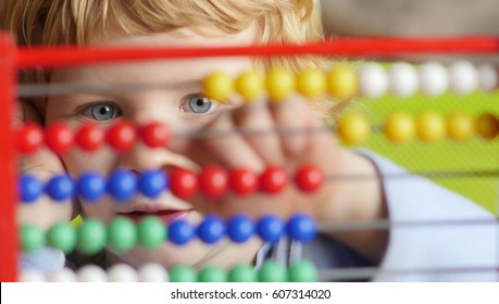 Young Caucasian Boy Early Learning Counting On Abacus.