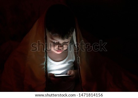 Similar – Boy reading with a flashlight