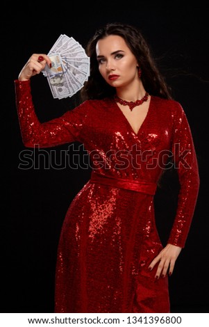 Young caucasian brunette woman holds in her hands a lot of money in the form of a fan, showing off her winnings