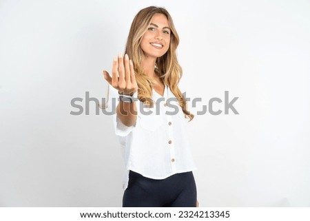 Young caucasian business woman wearing white shirt over white background inviting to come with hand. Happy that you came