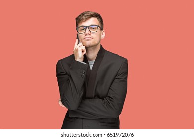 The young caucasian businessman on red background talking on cell phone