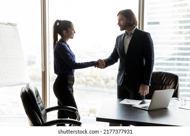Young Caucasian businessman shake hand of happy female client or colleague close deal at office meeting. Happy business partners handshake get acquainted greeting at briefing. Cooperation concept. - Shutterstock ID 2177377931