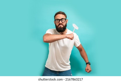 Young caucasian charismatic man holding a fly swatter wanting to kill annoying mosquito or a fly. - Shutterstock ID 2167863217