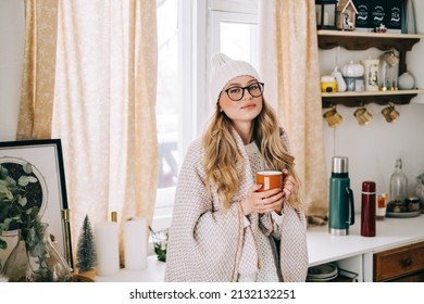 Young Caucasian Cheerful Woman Standing On A Kitchen And Drinking Tea On Winter Morning.