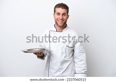 Young caucasian chef with tray isolated on white background with surprise facial expression
