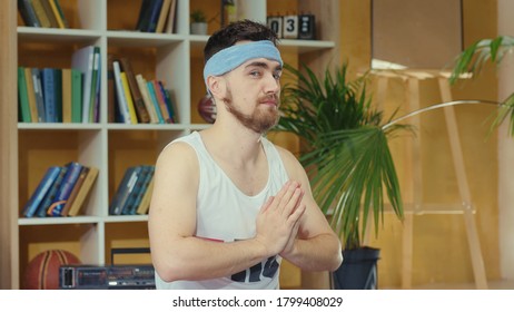 Young Caucasian Comical Man Wearing Fitness Outfit And Practicing Yoga. Silly Jerk Retro Guy Doing Meditating Asana And Spying Others Opening Eyes. Fitness Parody Concept.