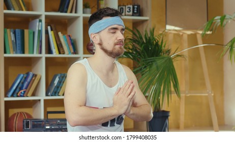 Young Caucasian Comical Man Wearing Fitness Outfit And Practicing Yoga. Silly Jerk Retro Guy Doing Meditating Asana And Spying Others Opening Eyes. Fitness Parody Concept.