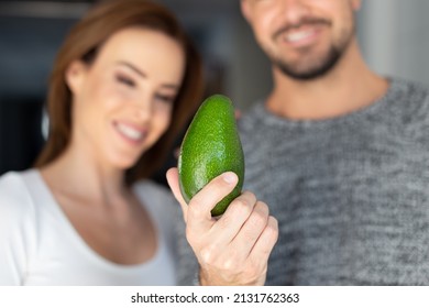 Young Caucasian Couple With Avocado, Man Holding, Depth Of Field