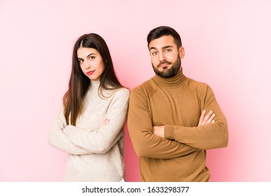 Young Caucasian Couple Isolated Unhappy Looking In Camera With Sarcastic Expression.