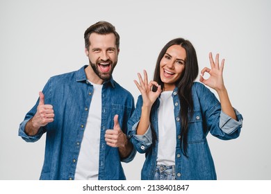 Young Caucasian Couple Man And Woman Husband And Wife Spouses Boyfriend And Girlfriend Showing Thumbs Up And Okay Gesture Looking At Camera Isolated In White Background. Quality Check