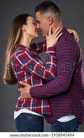 Young caucasian couple posing against gray background