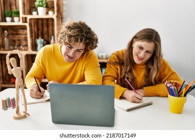 Young Caucasian Couple Smiling Confident Having Online Art Class At Home