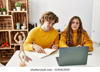 Young Caucasian Couple Smiling Confident Having Online Art Class At Home