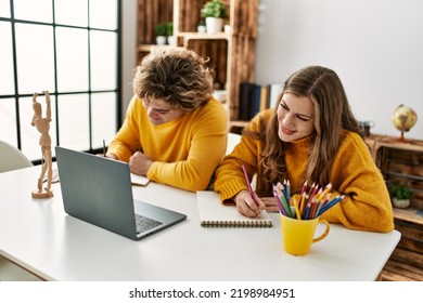 Young Caucasian Couple Smiling Confident Having Online Art Class At Home