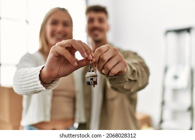 Young caucasian couple smiling happy holding key of new home. - Shutterstock ID 2068028312