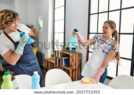 Young caucasian couple smiling happy playing shouting diffuser at home.