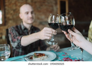 Young Caucasian Couple Toasting On Their Date At A Restaurant.