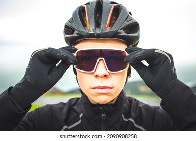 Young Caucasian Cyclist Man Fitting His Sun Glasses.