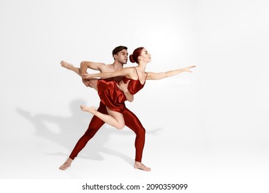 Young Caucasian Dance Couple Dancing Classical Ballet Dance. Choreography Concept. Man Holding Woman In Hands. Elegant Fit People Isolated On White Background In Studio. Copy Space