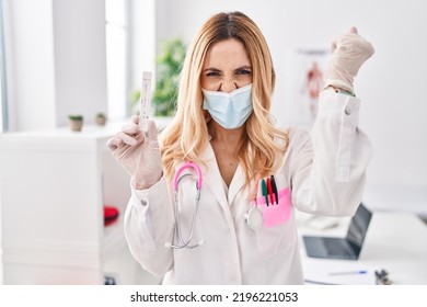 Young Caucasian Doctor Woman Holding Covid Test Annoyed And Frustrated Shouting With Anger, Yelling Crazy With Anger And Hand Raised 