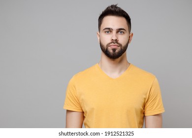 Young Caucasian European Serious Bearded Attractive Handsome Student Man 20s Wear Casual Yellow Basic T-shirt Looking Camera Isolated On Grey Color Background Studio Portrait People Lifestyle Concept