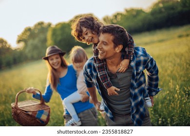 Young caucasian family having a picnic on a grassy field in nature - Powered by Shutterstock