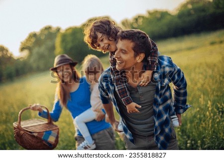 Young caucasian family having a picnic on a grassy field in nature