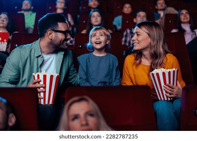 A young Caucasian family is spending their weekend hanging out together at the movie theater watching an entertaining movie together. - Shutterstock ID 2282787235