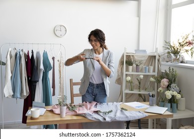 Young Caucasian female blogger or influencer photograph clothes on smartphone at home, millennial woman shoot clothing shopping haul on cell, modern fashion designer picture new dresses on camera - Shutterstock ID 1757362124