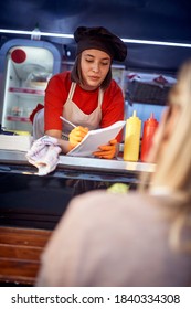 Young Caucasian Female Employee In Fast Food Service Taking Order From A Customer, Writing Down On A Paper