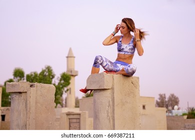Young caucasian female practising yoga in abandoned ruins in Ras al Khaimah, United Arab Emirates - June 2017