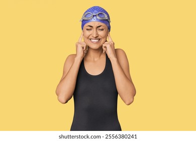 Young Caucasian female professional swimmer covering ears with hands. - Powered by Shutterstock