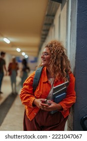 A Young Caucasian Female Student Is Waiting With Her Book In The College Hallway For Her Classes To Begin.