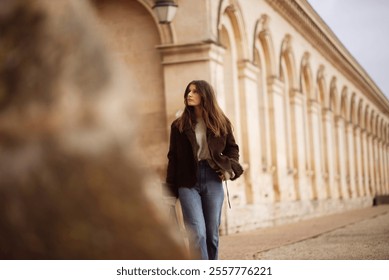 Young caucasian female walking along historic stone architecture. - Powered by Shutterstock