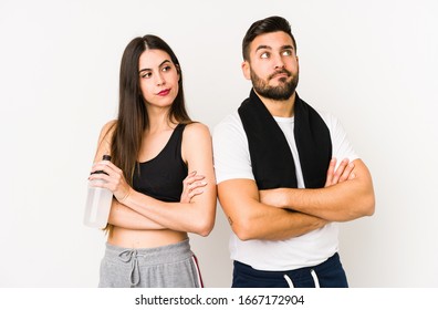 Young Caucasian Fitness Couple Isolated Unhappy Looking In Camera With Sarcastic Expression.