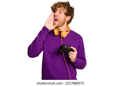 Young Caucasian Gamer Man Holding A Game Controller Isolated On White Background Shouting And Holding Palm Near Opened Mouth.