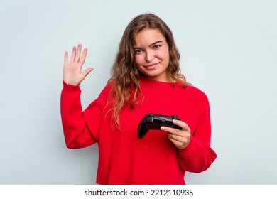 Young Caucasian Gamer Woman Holding A Game Controller Isolated On Blue Background Smiling Cheerful Showing Number Five With Fingers.