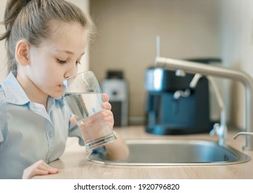 Young caucasian girl is holding a glass with water. Concept of good quality clean water. Kitchen faucet. Pouring fresh drink. Hydration. Healthy lifestyle. World water day. Environmental problem