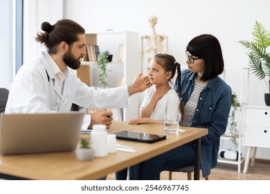 Young Caucasian girl with mother at doctor's office during medical consultation. Female doctor examines child while discussing health concerns. - Powered by Shutterstock