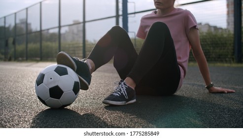 Young caucasian girl practicing soccer skills and tricks with the football ball at sunset in an playground. Urban city lifestyle outdoors concept - Powered by Shutterstock