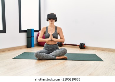 Young Caucasian Girl Using Vr Goggles Training Yoga At Sport Center.