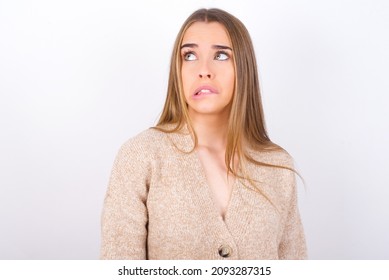 young caucasian girl wearing knitted sweater over white background making grimace and crazy face, screaming out of control, funny lunatic expressing freedom and wild.