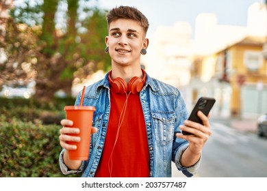 Young Caucasian Guy Drinking Soda Using Smartphone At The City