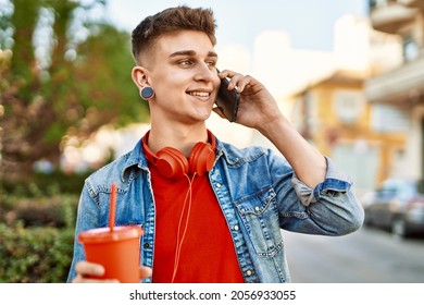 Young Caucasian Guy Drinking Soda Speaking On The Phone At The City