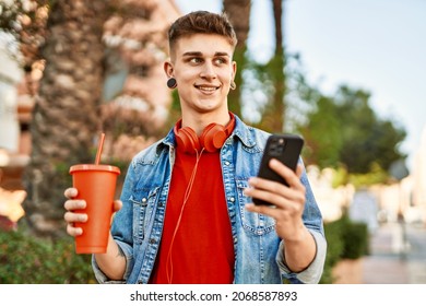 Young Caucasian Guy Drinking Soda Using Smartphone At The City