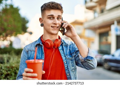 Young Caucasian Guy Drinking Soda Speaking On The Phone At The City