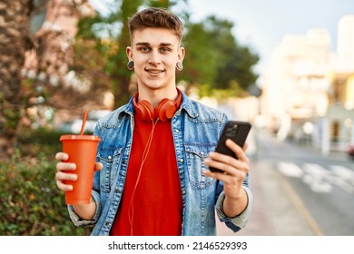 Young Caucasian Guy Drinking Soda Using Smartphone At The City