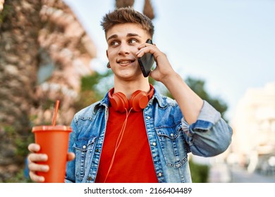 Young Caucasian Guy Drinking Soda Speaking On The Phone At The City