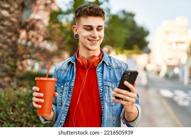 Young Caucasian Guy Drinking Soda Using Smartphone At The City