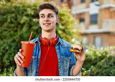 Young Caucasian Guy Eating Burger And Soda At The City